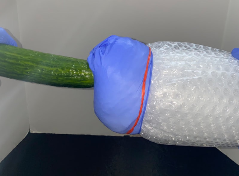 A homemade fleshlight using bubble wrap a rubber band and a latex glove with a condom inside.